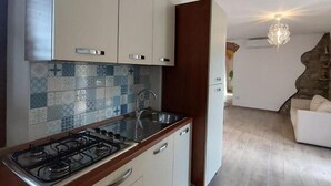 A modern kitchen with a gas stove, white cabinets, and a patterned backsplash. - Cuore Verde del Cilento (Laureana Cilento)