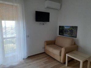 Dreibettzimmer, Balkon, eingeschränkter Meerblick | Wohnbereich