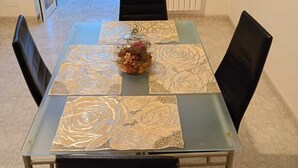 A dining table with a patterned tablecloth, black chairs, and a decorative centerpiece. - ANNA LITTLE HOUSE Vacation Home (Bari)