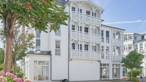 A multi-story building with balconies, large windows, and a gravel driveway. - Moderne Ferienwohnung im Seepark Sellin mit Balkon (Sellin)