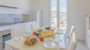 Eine moderne Küche mit Essbereich, Blick auf die Stadt und einem Balkon.