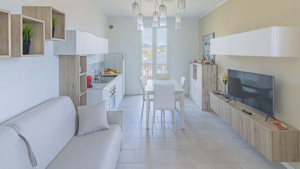 Eine moderne Wohnung mit Wohnzimmer, Essbereich, Küche und Fernseher.