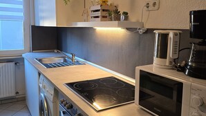 Una cocina moderna con horno empotrado, microondas y estufa.