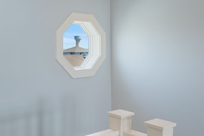 A bathroom with a hexagonal mirror, a toilet, and a pedestal sink. - The Big Fish on Redfish - amazing views, hot tub, outdoor bar, and more!! (Crystal Beach)