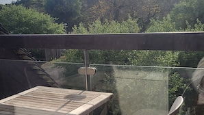 A balcony with a table and chairs, overlooking a hilly landscape. - Charming studio apartment, located in a quiet residential complex near the beach in Le Touquet (Paris)