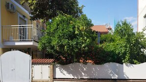 A residential building with a white gate, a balcony, and a tree in the foreground. - Vacation Apartments Along the Agropoli Seafront (Agropoli)