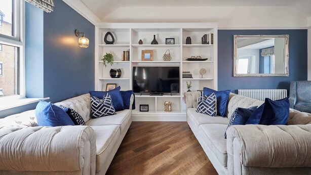 A living room with two sofas, a TV, and a bookshelf. - Host Stay - Welton Mews (Whitby)