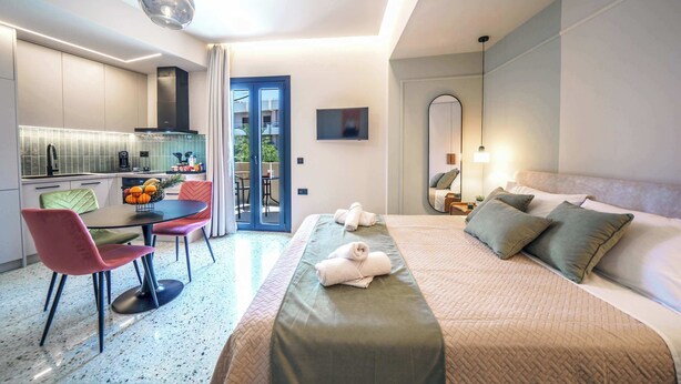Ein modernes Hotelzimmer mit einem Bett, einem Essbereich und einer Küche.
