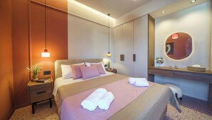 A hotel room with a bed, bedside table, and a mirror. - Noble Heraklion Suites Terra Suite in Crete (Heraklion)