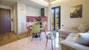 A modern apartment with a dining area, kitchen, and living room. - Noble Heraklion Suites Terra Suite in Crete (Heraklion)