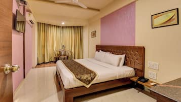 A hotel room with a bed, bedside table, and a ceiling fan.