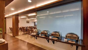 A buffet setup with multiple serving stations, each with a covered food container and labeled with a dish name.