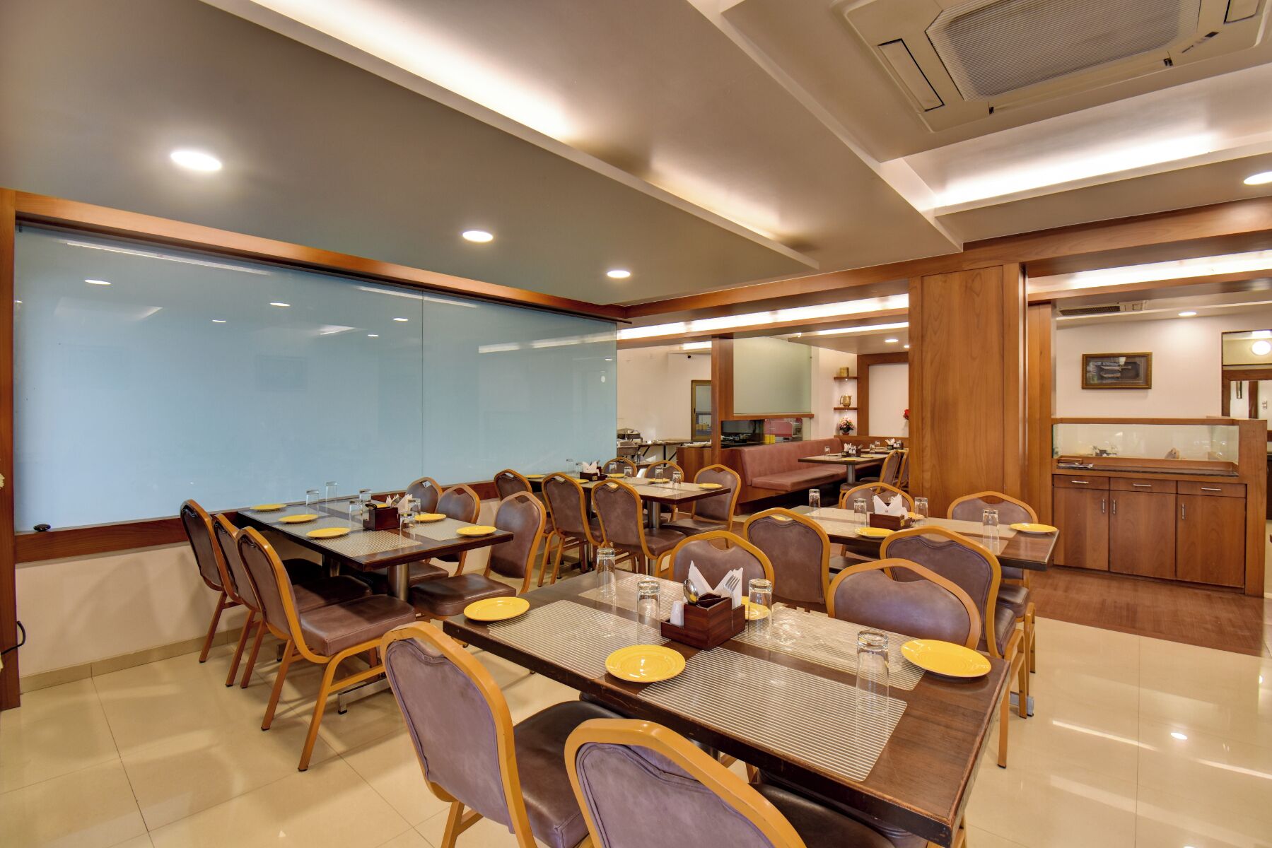 A conference room with a large table, chairs, and a glass partition.
