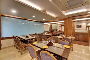 A conference room with a large table, chairs, and a glass partition. - Hotel Bhagyalaxmi (Shirdi)
