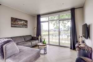 Un salon avec un canapé, une table basse et un téléviseur.