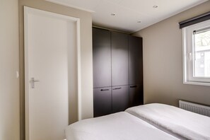 Une chambre à coucher avec un lit, une armoire et une fenêtre.