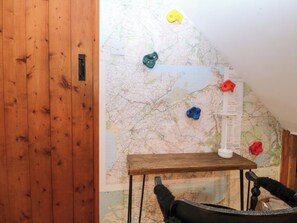 A wooden wall with a map, a small table, and a chair. - Waterfall Retreat (Blaenau Ffestiniog)