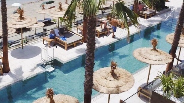 A poolside area with lounge chairs, umbrellas, and palm trees. - Spectacular flat, ideal for family holidays – Monte Miraflores (AN)