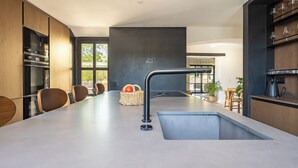 Una cucina moderna con isola centrale, elettrodomestici integrati e un'ampia finestra.