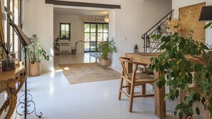 Un'ampia cucina con zona pranzo, una scala e vista sul soggiorno.