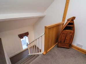 Eine Treppe mit Holzwandhandlauf und Teppichboden.