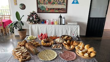 Una mesa de buffet con diferentes alimentos, un adorno navideño y un cuadro en la pared.