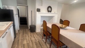 Eine Küche mit Essbereich, Holzboden, weißen Schränken und einem eingebauten Backofen.
