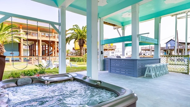 A hot tub with a view of a building and palm trees. - The Big Fish On Redfish 4 Bedroom Home (Port Bolivar)