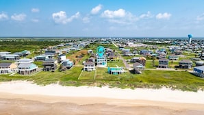 A coastal residential area with houses, a beach, and a water tower. - The Big Fish On Redfish 4 Bedroom Home (Port Bolivar)
