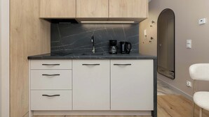 Eine moderne Küche mit schwarzer Marmorarbeitsplatte, Holzschränken und einer integrierten Kaffeemaschine.