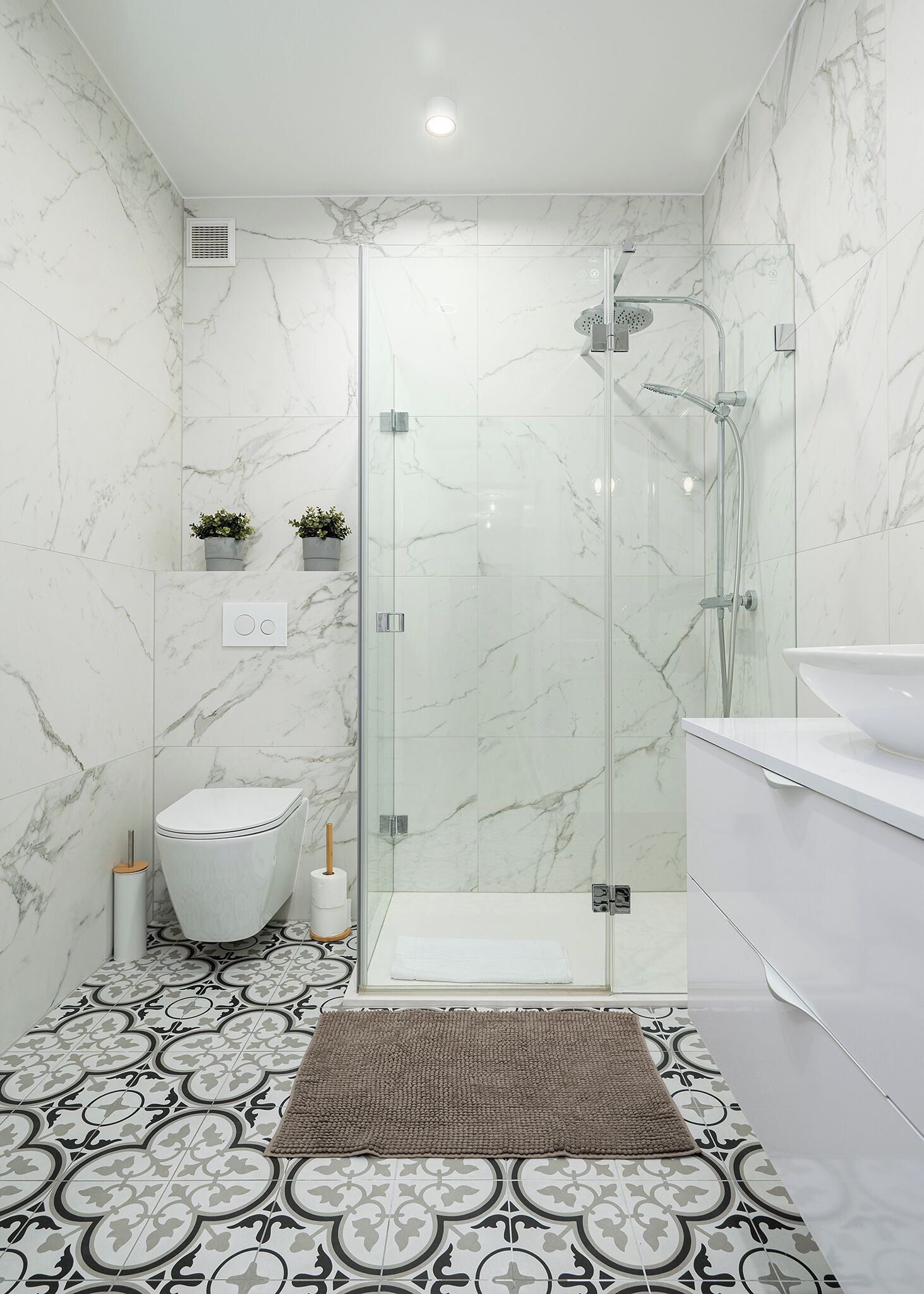 Un baño moderno con ducha de vidrio, inodoro y lavamanos.