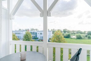 Ein Balkon mit Blick auf ein Gebäude und Bäume.