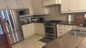 A kitchen with stainless steel appliances, white cabinets, and a granite countertop. - Charming, Family Friendly 3 bedroom House with Home Theatre near airport/transit (Toronto)