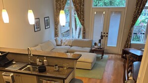 A modern kitchen with a dining area, a sofa, and a view of the outdoors. - Charming, Family Friendly 3 bedroom House with Home Theatre near airport/transit (Toronto)