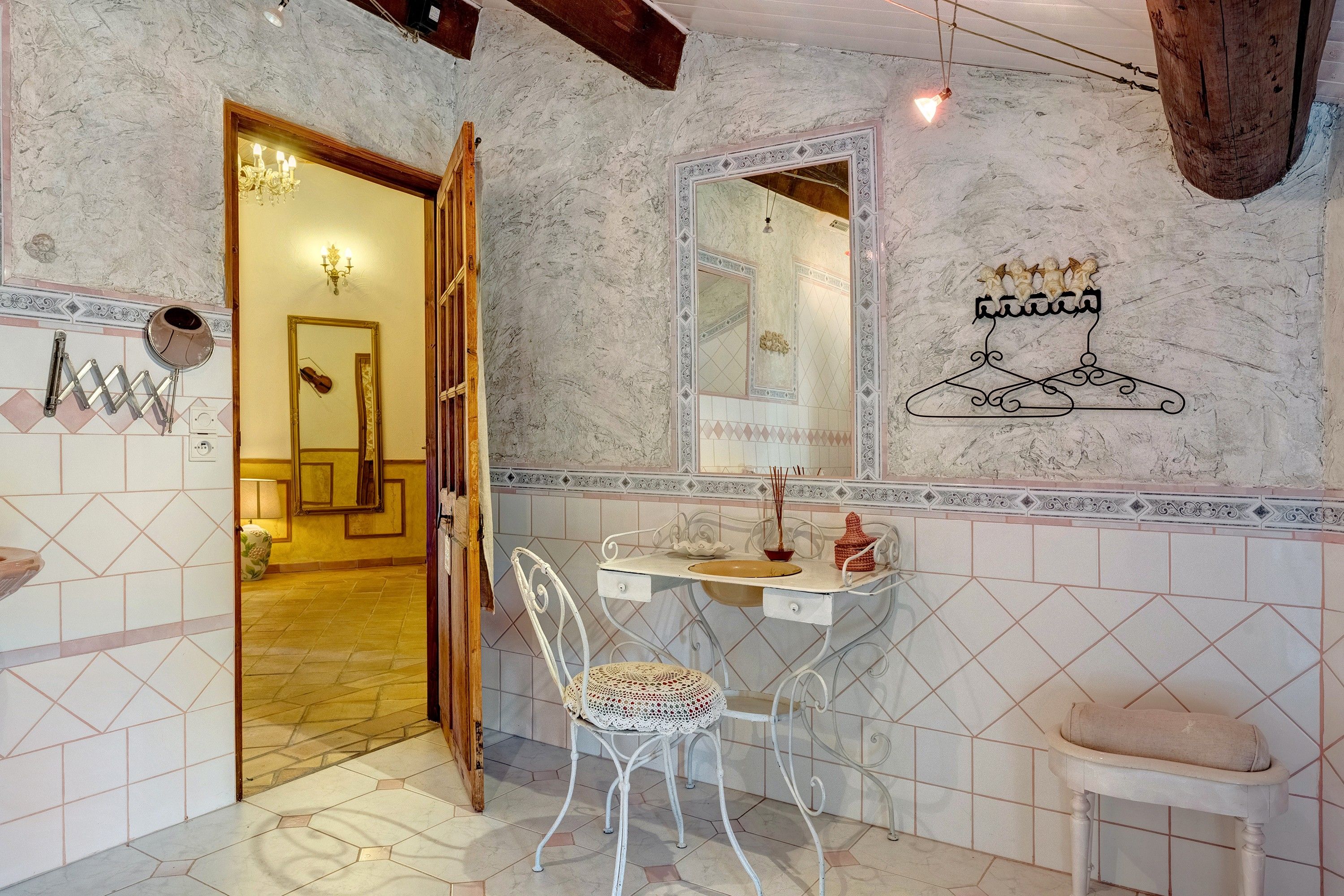 Un baño con un lavamanos blanco, un espejo y un adorno en la pared.