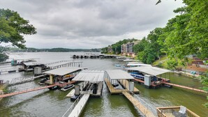 A marina with docked boats, a covered seating area, and a view of the water and surrounding greenery.