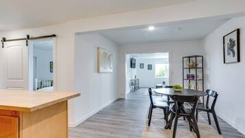 Uma cozinha moderna com bancada de madeira e área de jantar com mesa e cadeiras redondas.