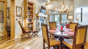 A dining area with a round table, wooden chairs, and a chandelier. - Gateway to the Teton Valley! Luxe Mtn Condo (Victor)