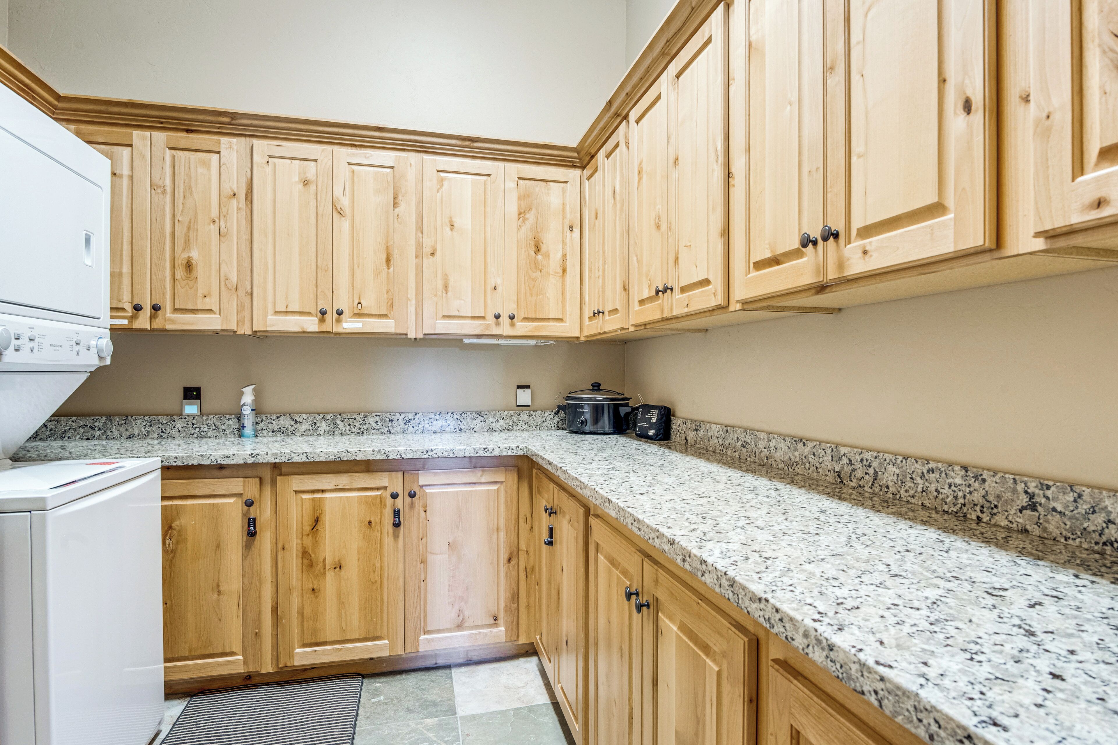 A kitchen with wooden cabinets, granite countertops, a built-in oven, and a microwave.