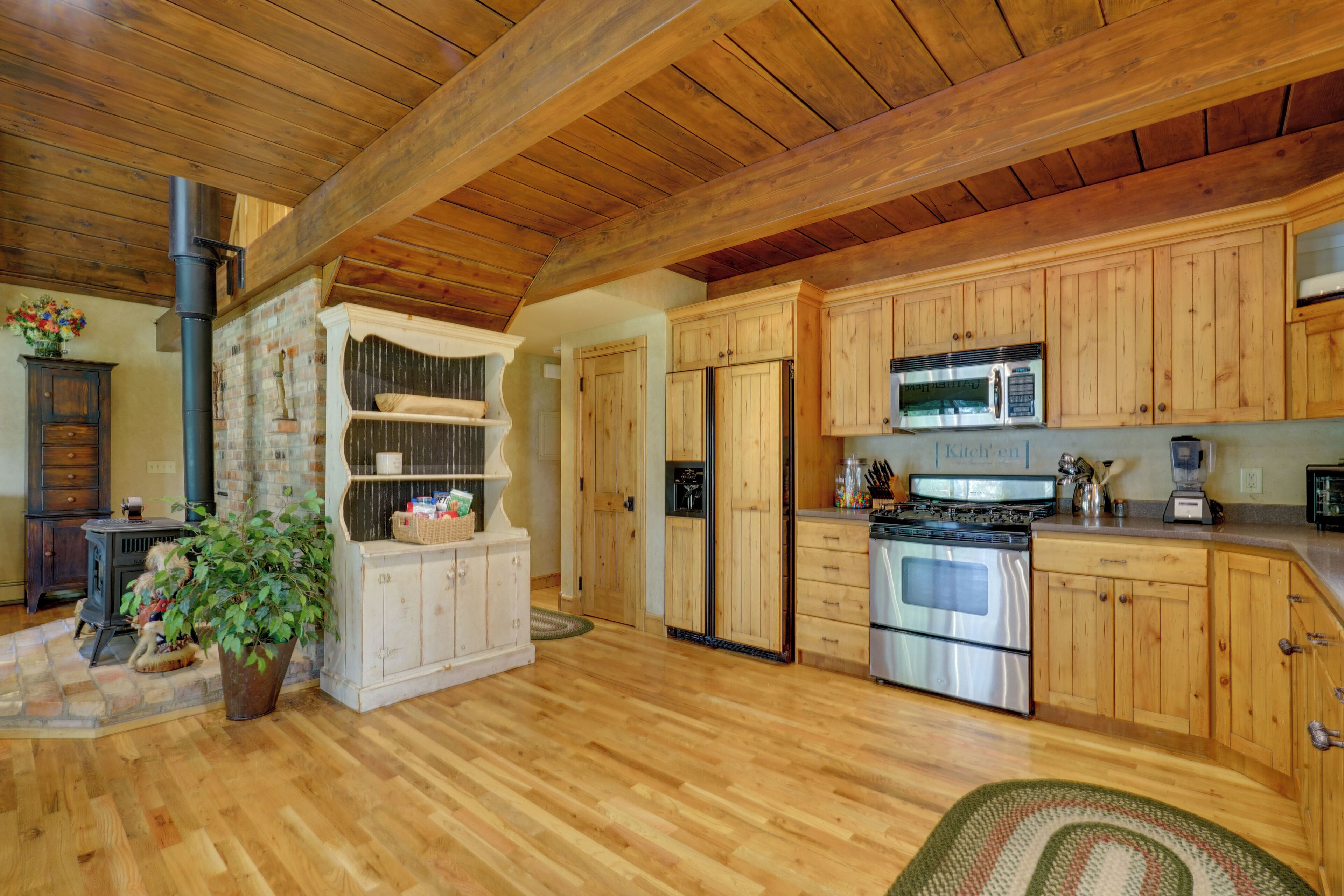 A kitchen with wooden cabinets, a stove, and a microwave.