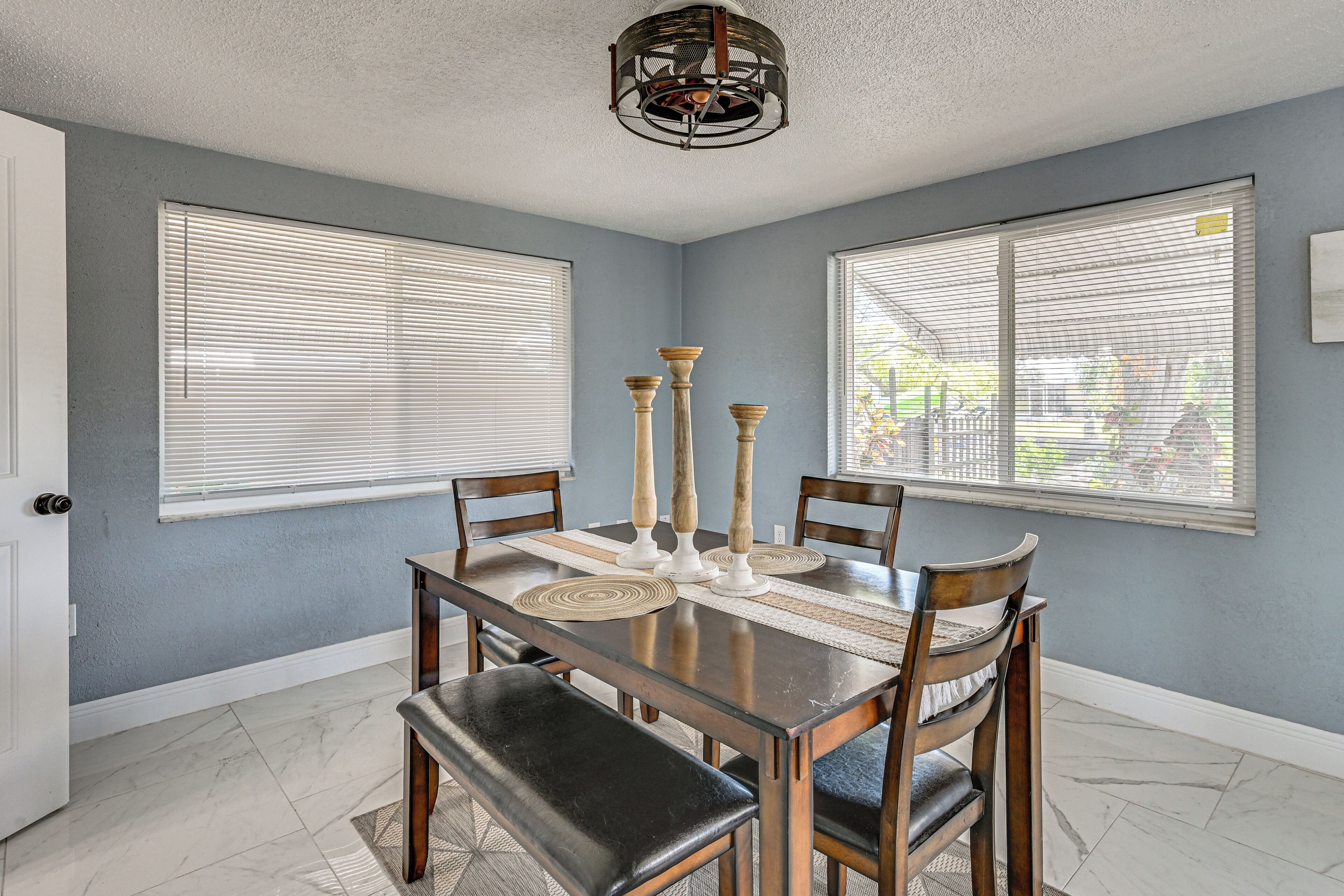 A dining area with a table, chairs, and a chandelier.