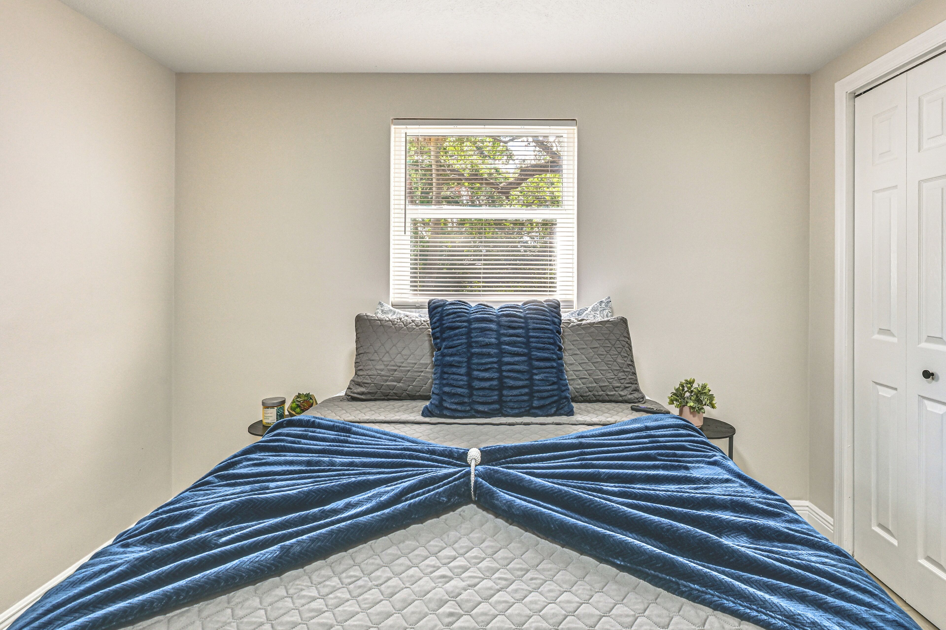 Quarto com cama, janela e porta.