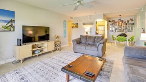 A living room with a television, sofa, coffee table, and a ceiling fan. - Steps to Pool & Ocean! Key Colony Beach Retreat (Key Colony Beach)