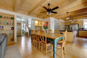 A spacious kitchen with wooden cabinets, a central island, and a ceiling fan.