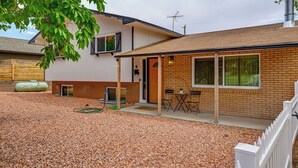 A two-story house with a covered porch, a brick exterior, and a gravel driveway. - Spacious Kanab Basecamp Game Rm, Patio, Fire Pit (Kanab)