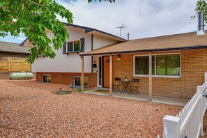 A two-story house with a covered porch, a brick exterior, and a gravel driveway. - Spacious Kanab Basecamp Game Rm, Patio, Fire Pit (Kanab)