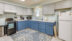 A kitchen with light blue cabinets, a white refrigerator, a stove, and a microwave. - Great for Families! Tillamook Getaway Near Beaches (Tillamook)