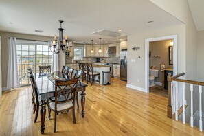 A spacious kitchen with a dining area, large windows, and a view of the outside. - Walk to Brigantine Beach! Family Townhome w/ Views (Brigantine)
