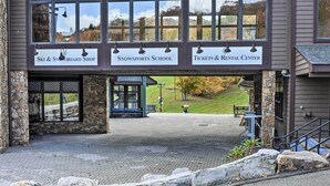 A building with a ski and snowboard shop, a snow sports school, and a tickets & rental center.