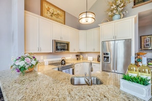 A kitchen with white cabinets, stainless steel appliances, granite countertops, and a hanging light fixture. - Community Perks! Somerset Retreat w/ Private Deck (Somerset)